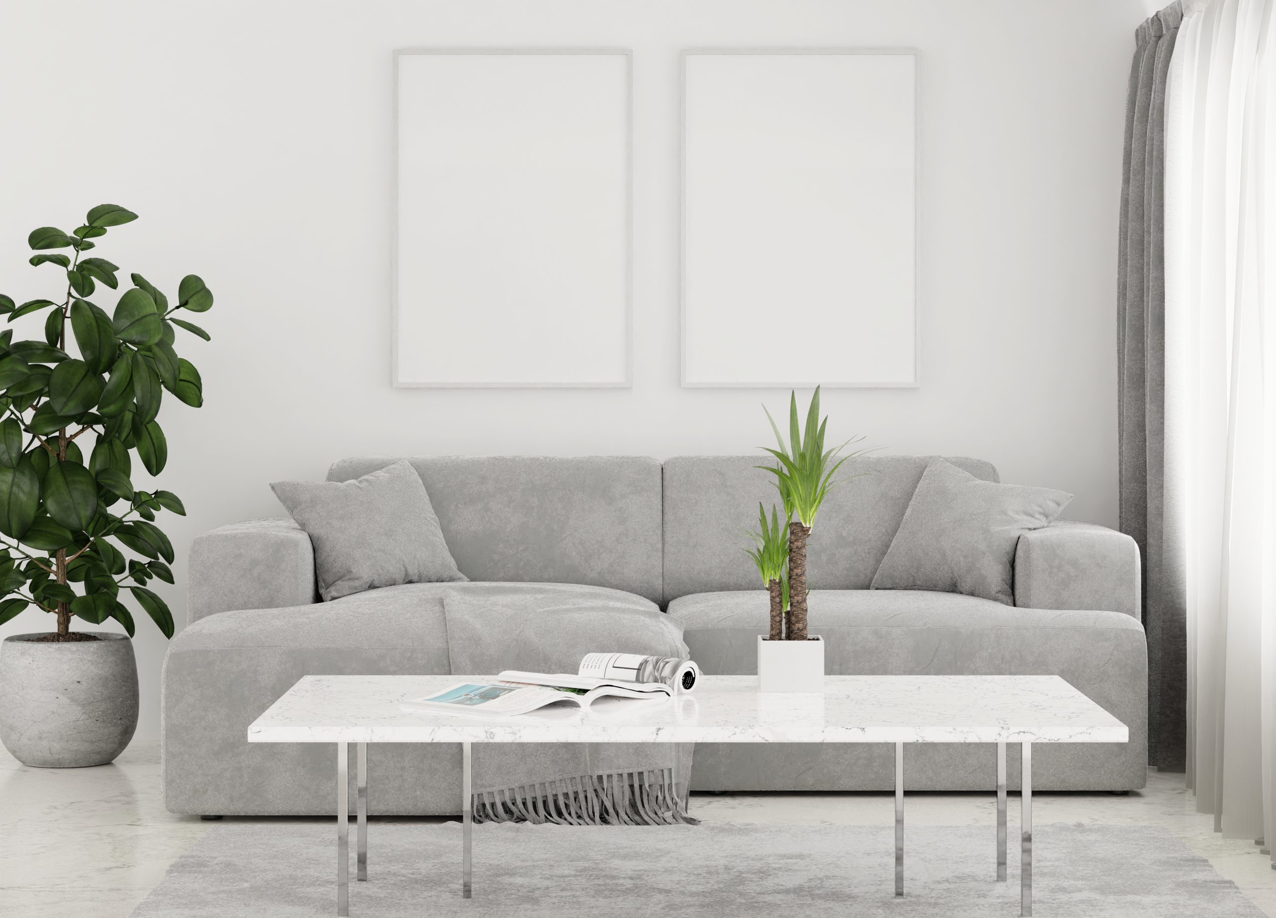 Minimalist living room with grey sofa, two framed artworks, a coffee table, and two potted plants.